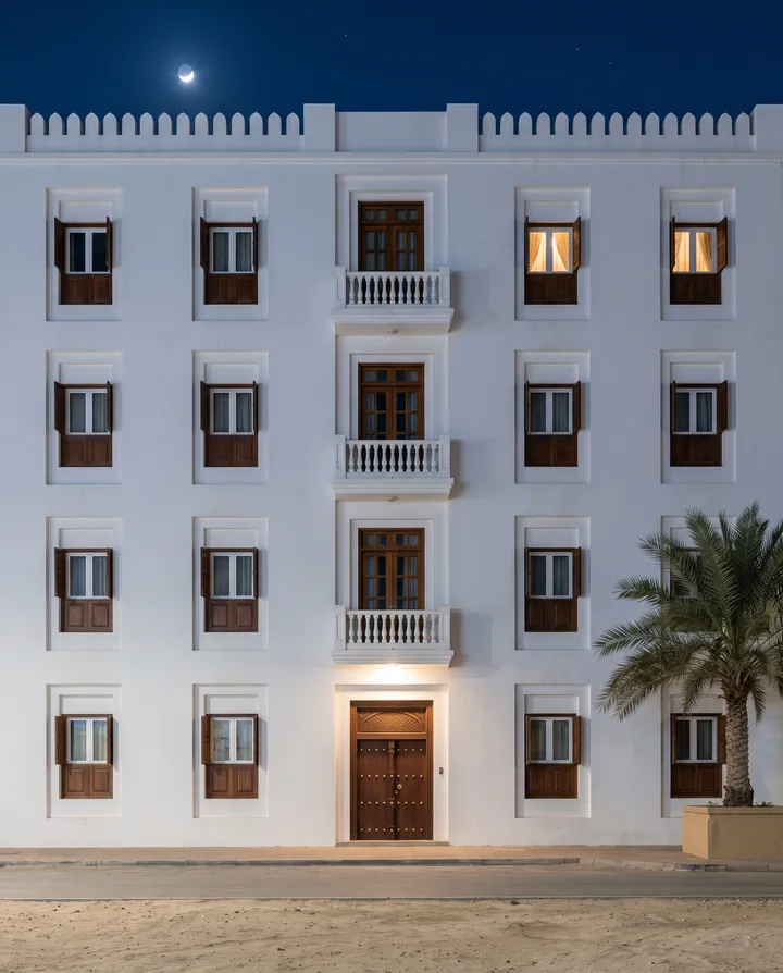 The building at night, two windows lit.
